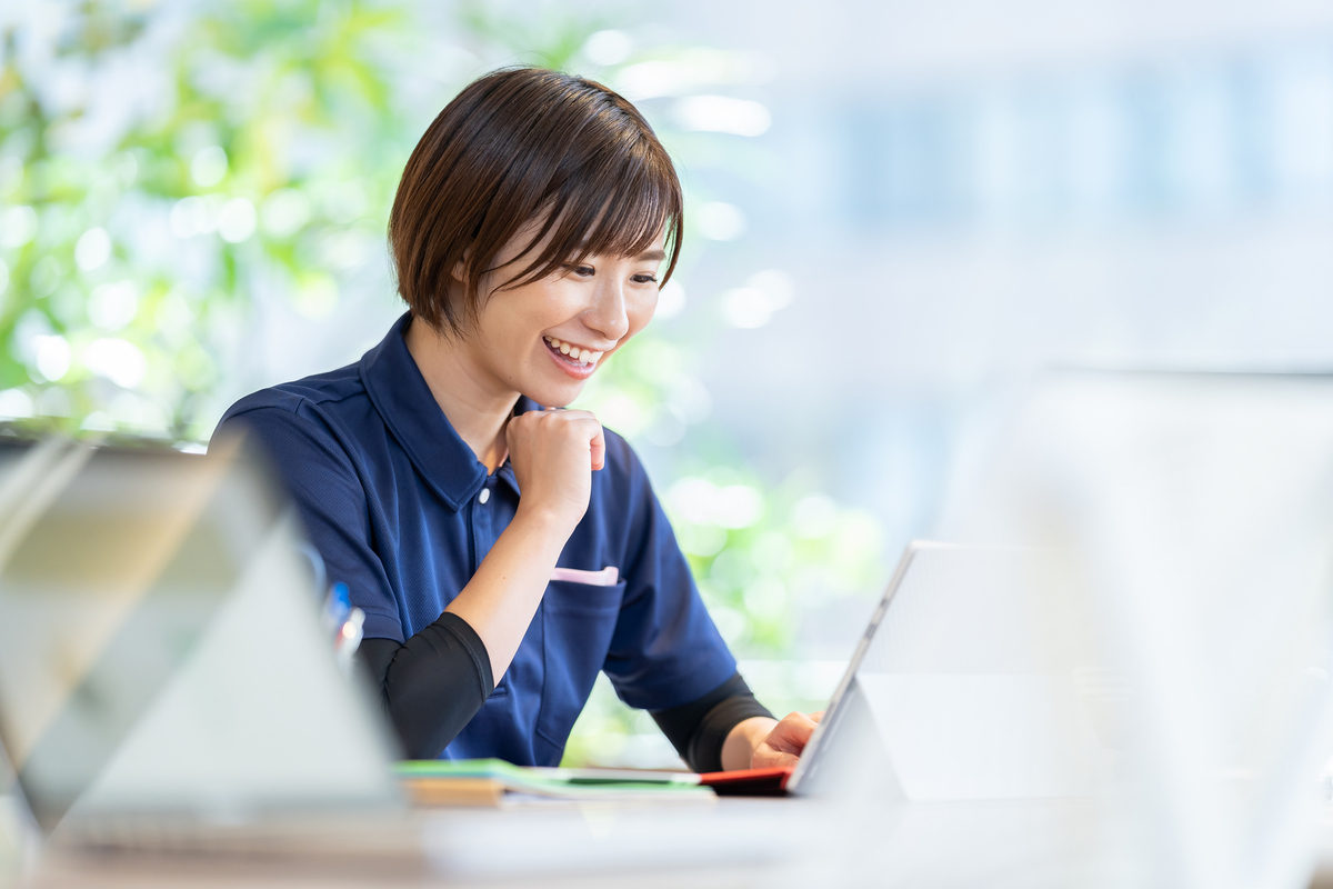 パソコンの前で笑顔の女性介護士