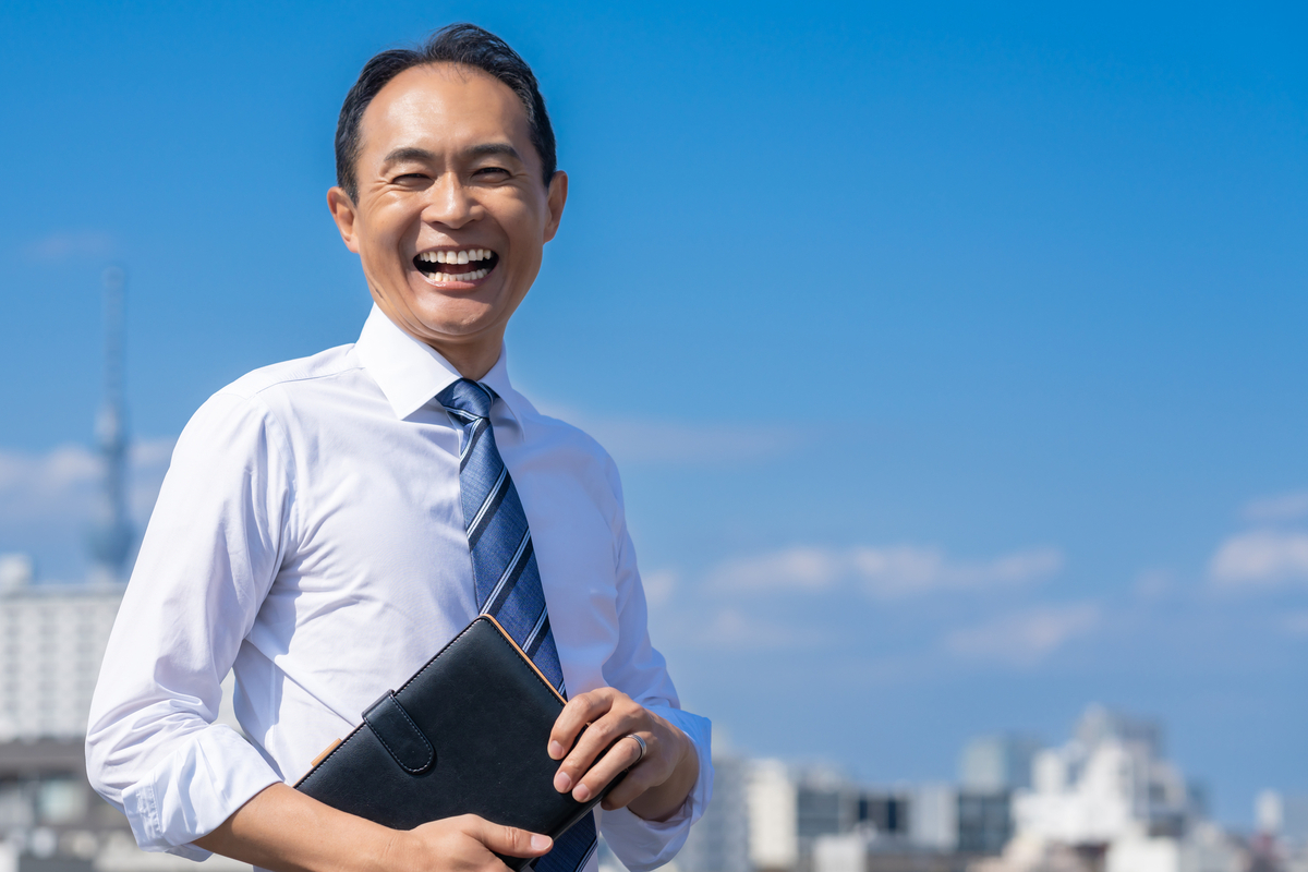 屋外で満面の笑みの男性