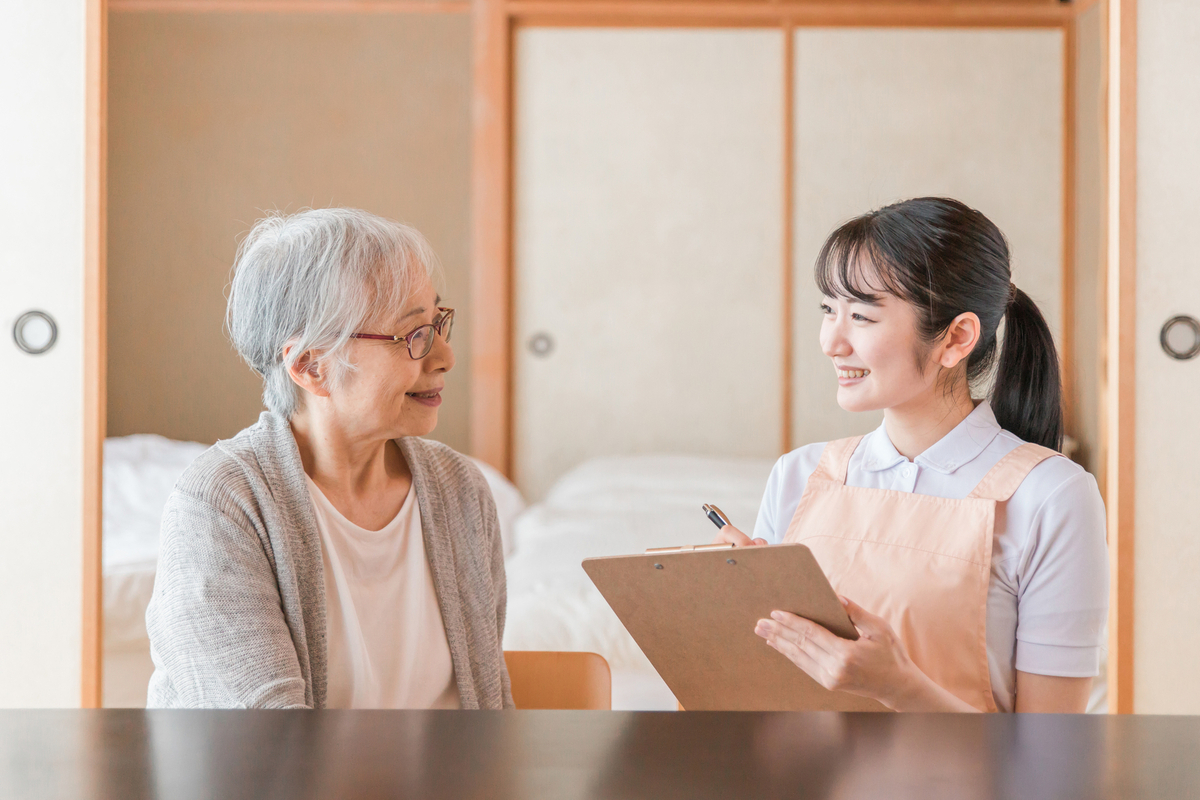 シニア女性と話す女性職員