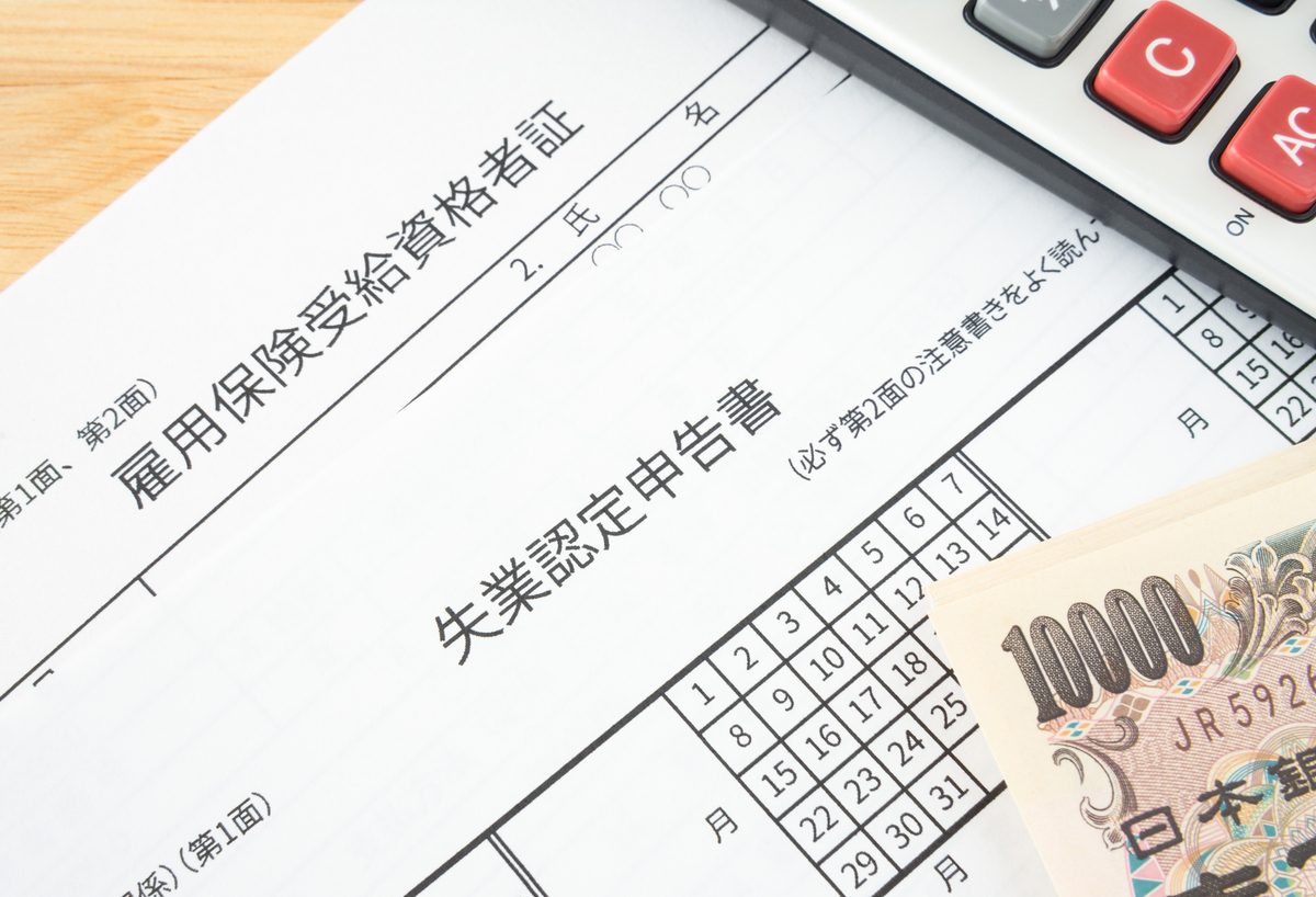 失業保険の書類と電卓と一万円札