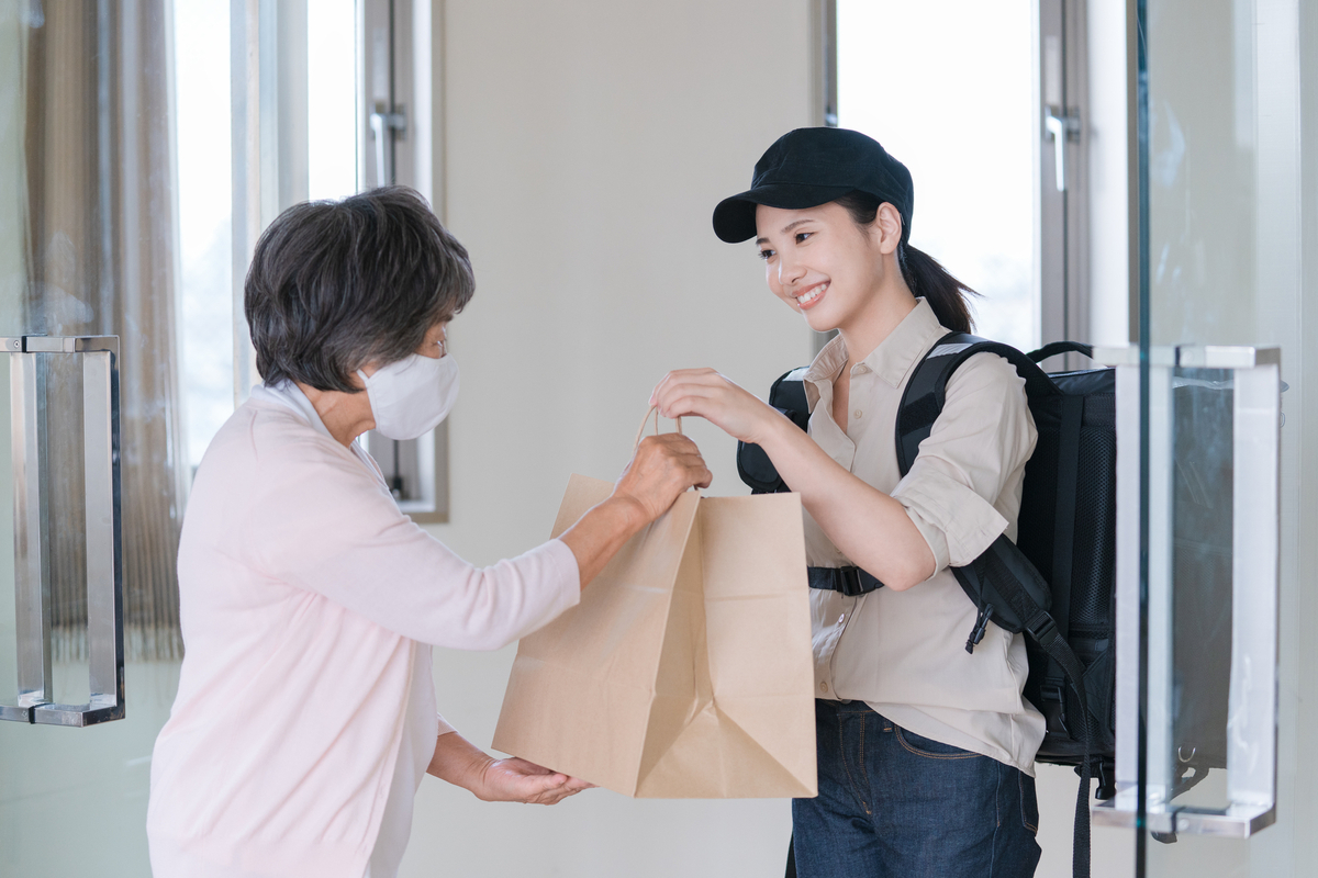 デリバリーの注文を渡す女性