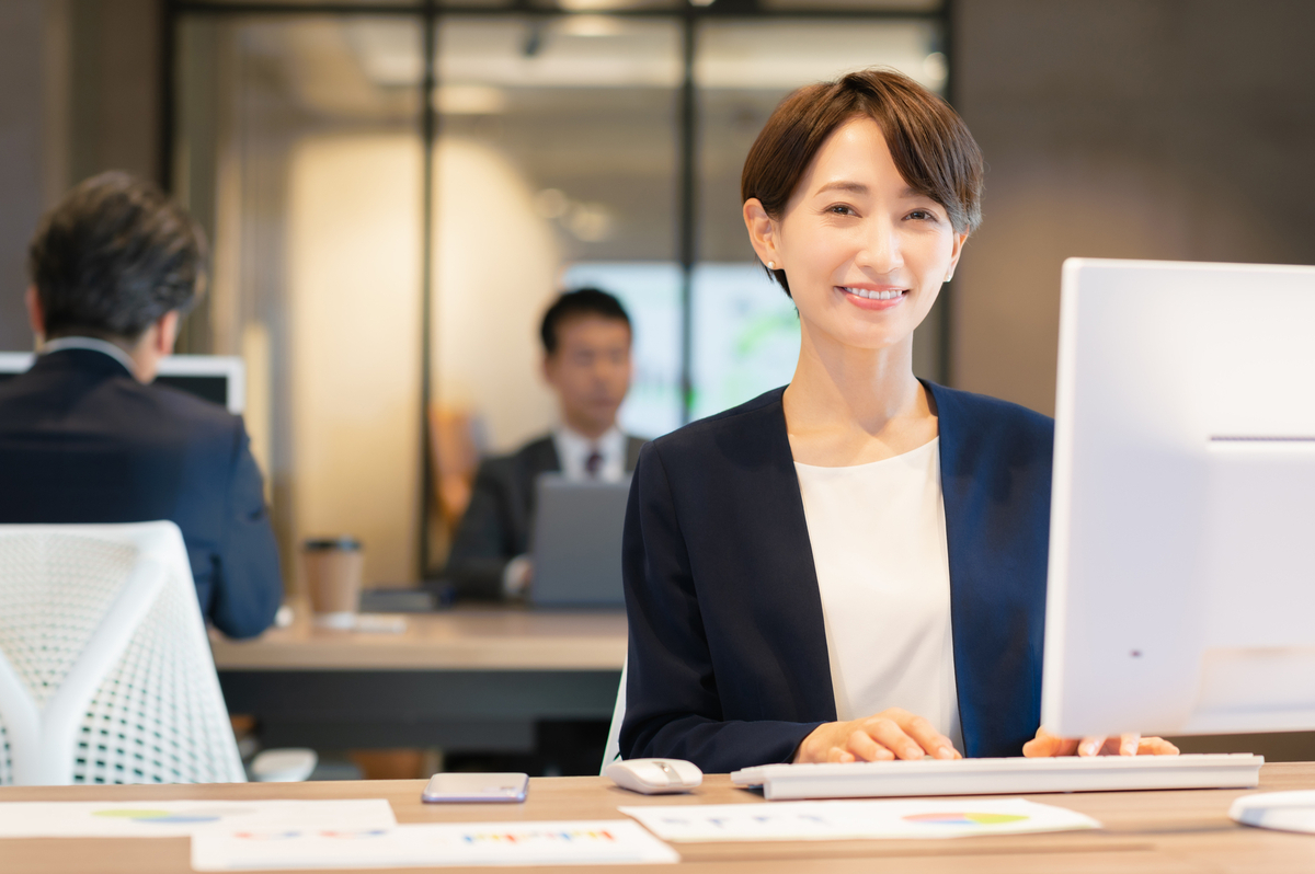 パソコン前で笑顔の女性