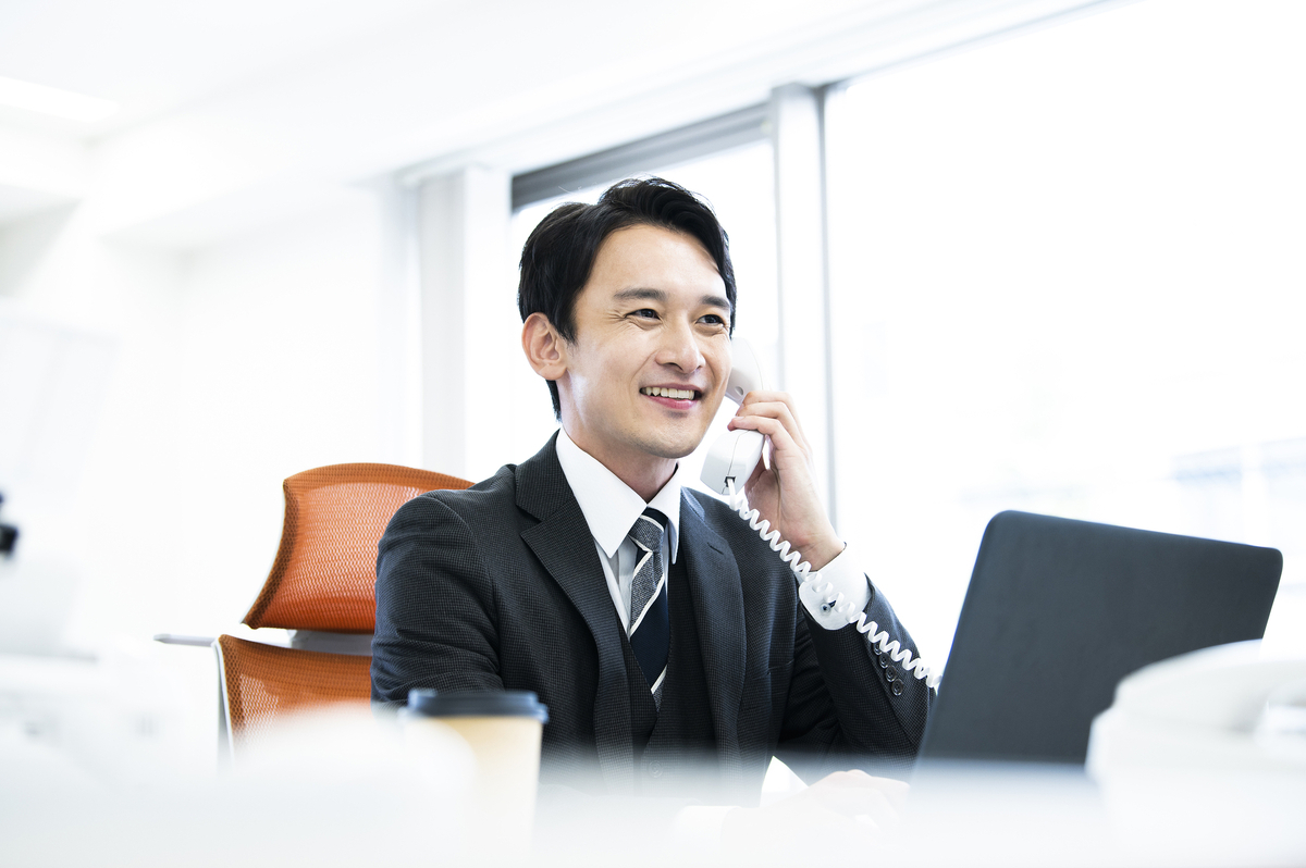 笑顔で電話を取る男性
