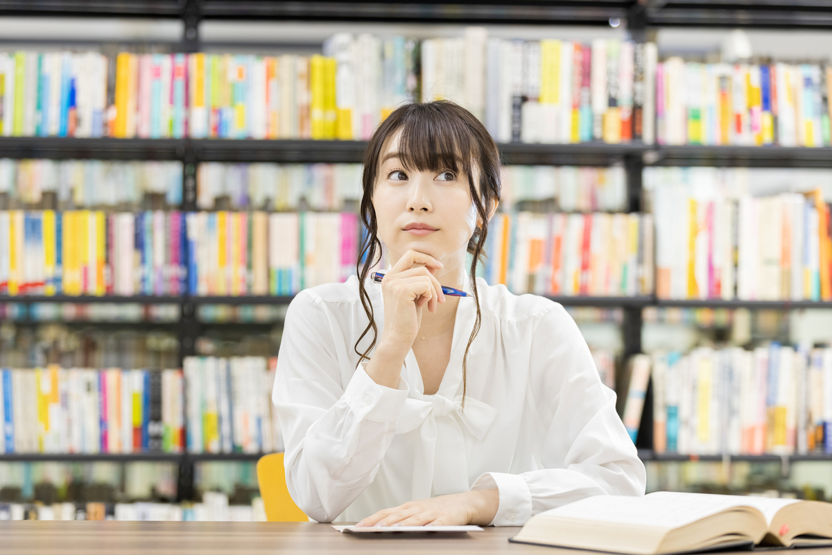 図書館で考え事をする女性