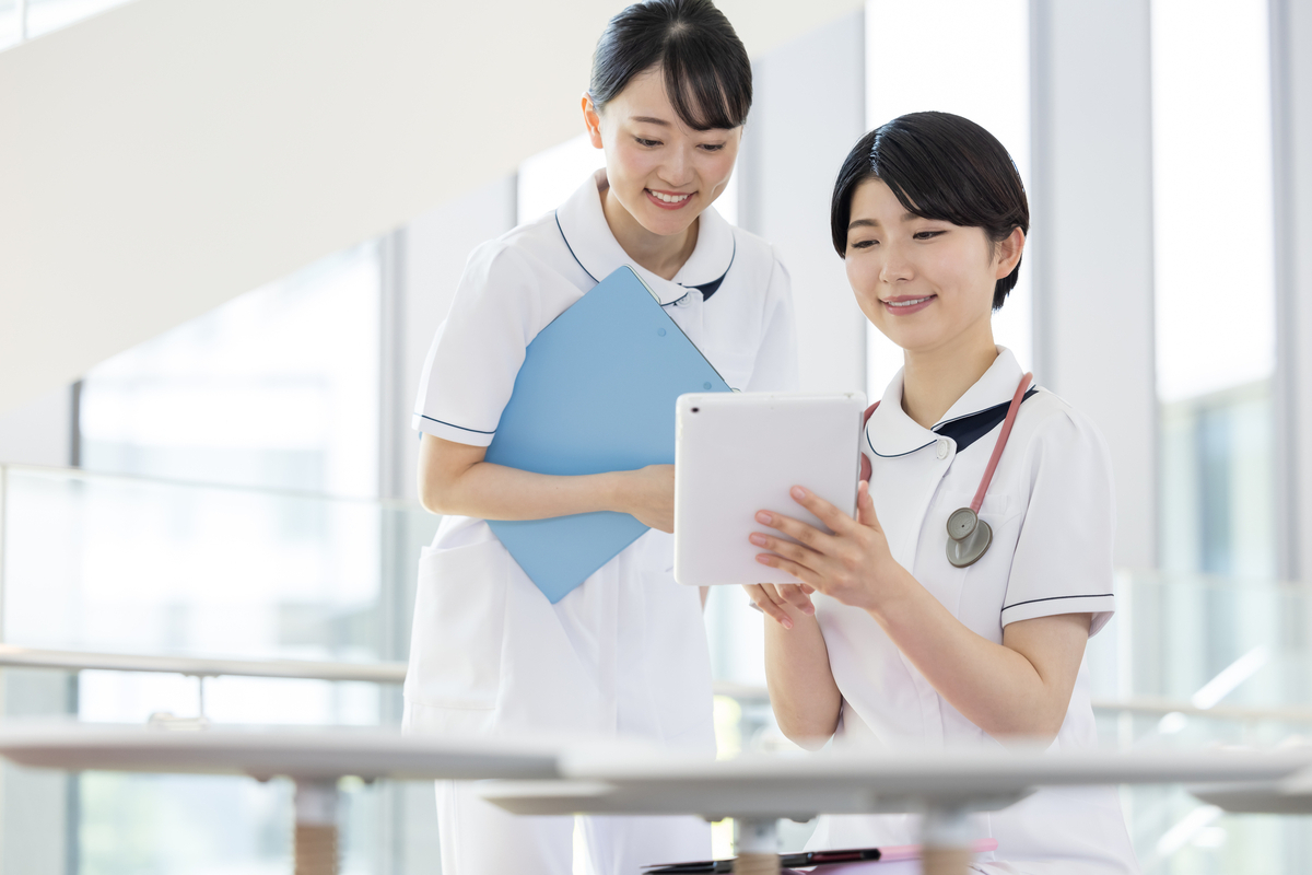 二人でタブレットを見る女性看護師