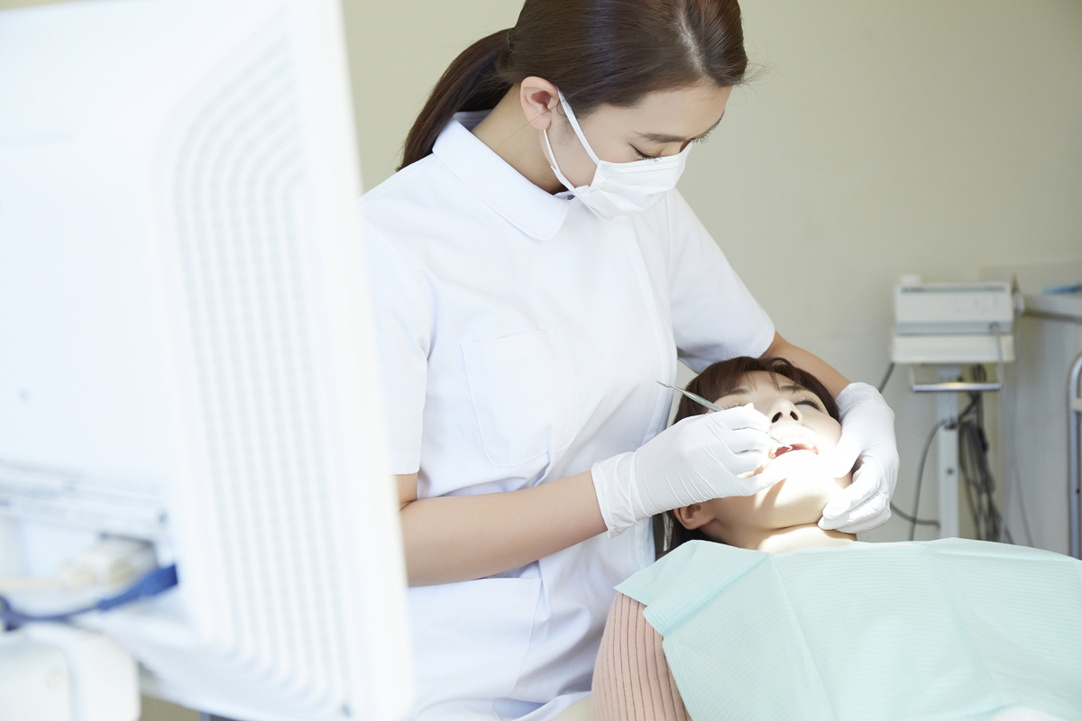 患者への施術を行う女性歯科衛生士