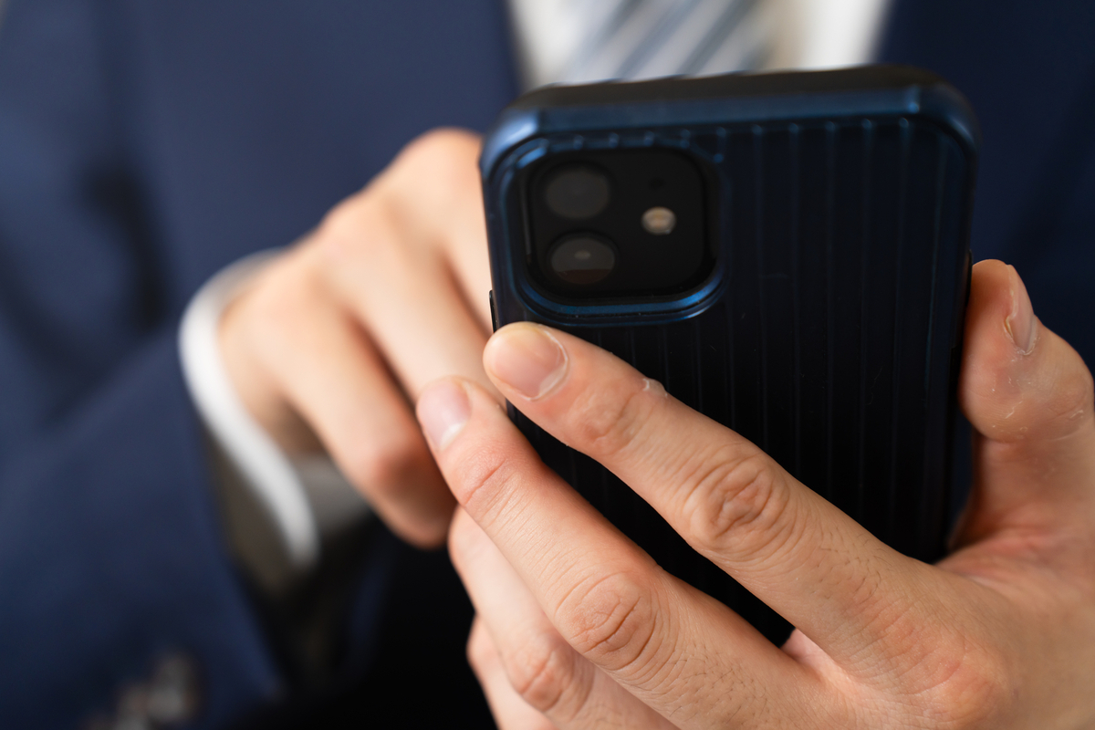 スマートフォンを操作する男性の手元
