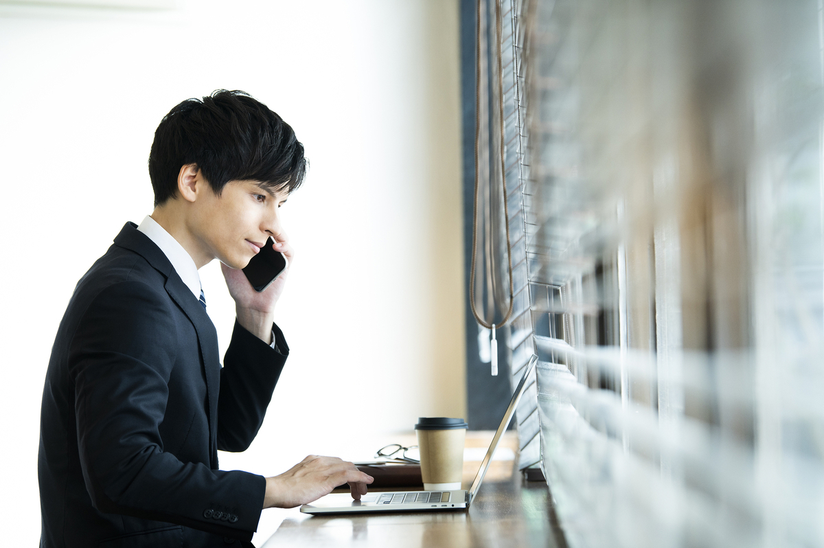 窓際で電話をする男性
