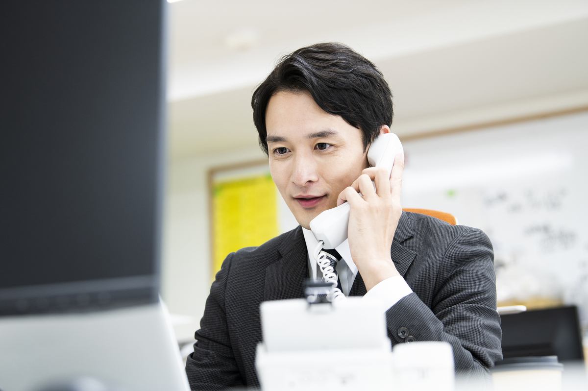 オフィスで電話をかける男性