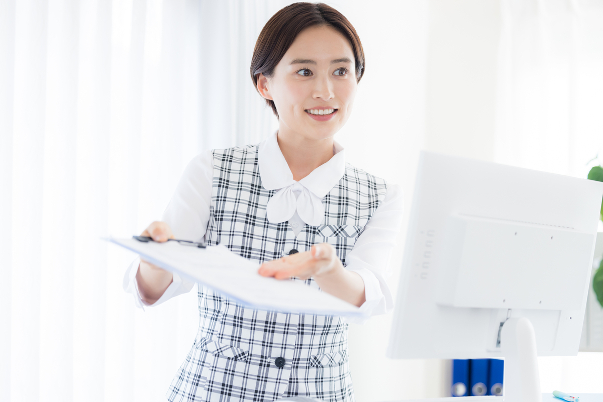 バインダーを手で示す女性