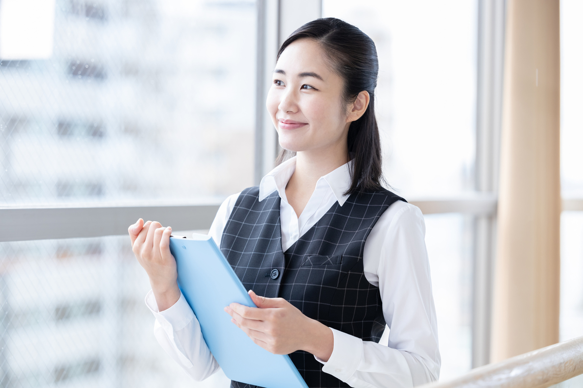 バインダーを持つ女性