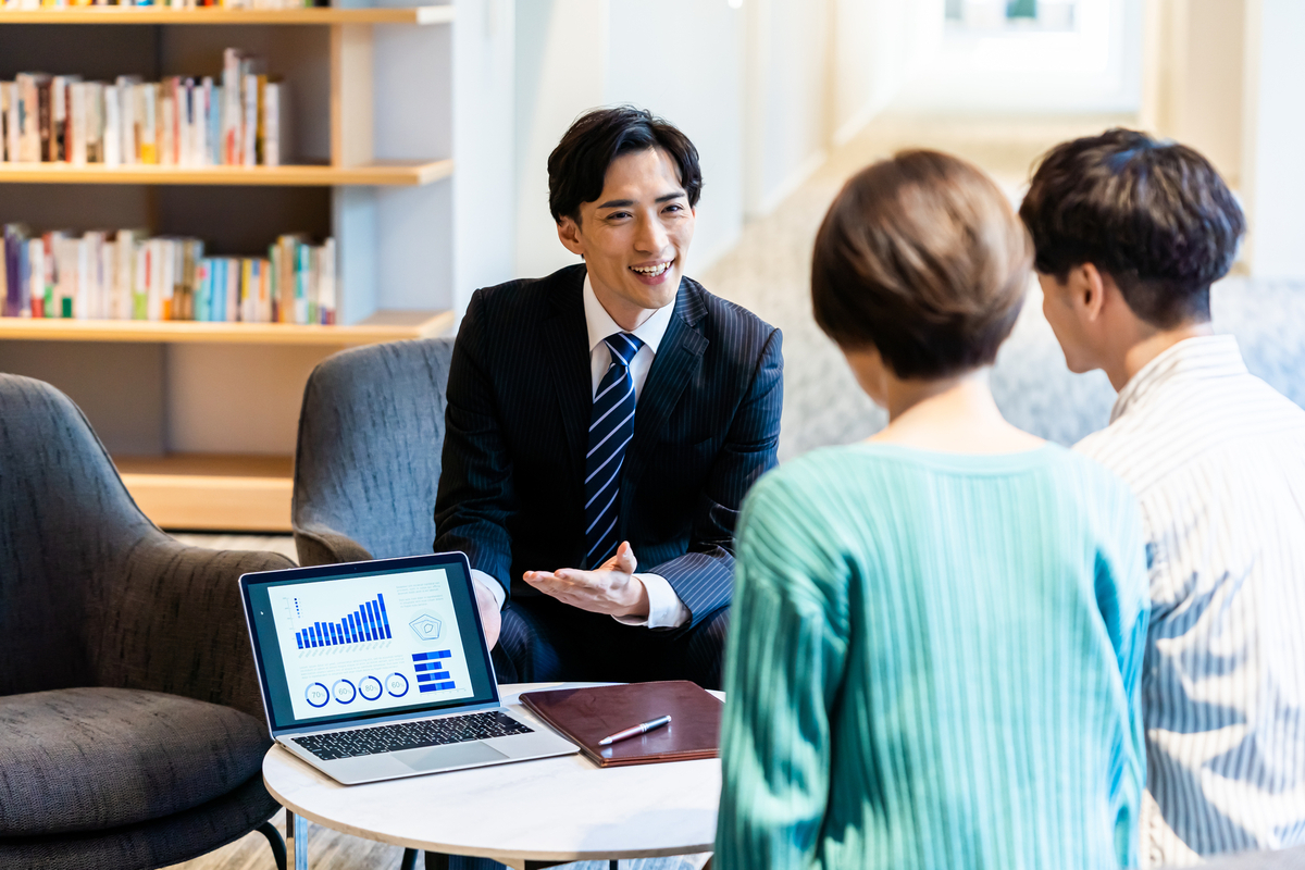 夫婦に営業をするビジネスパーソン