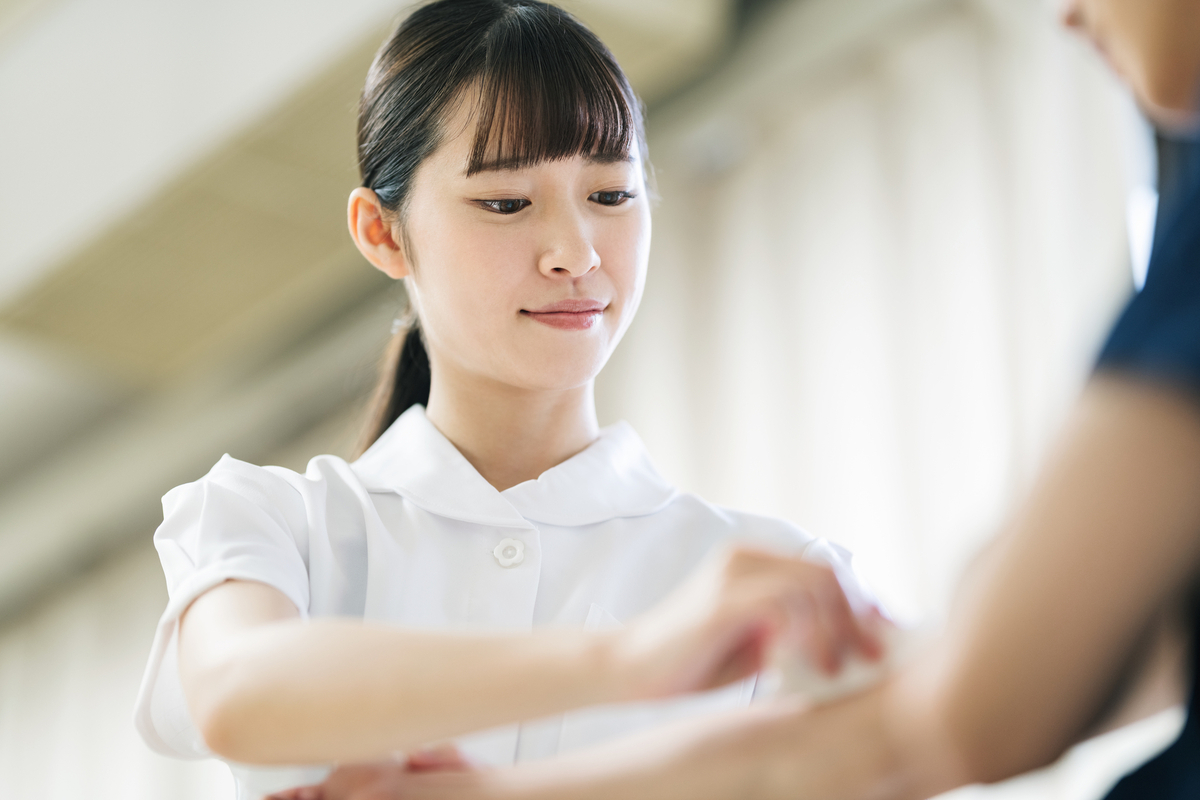 患者の腕を消毒する看護師