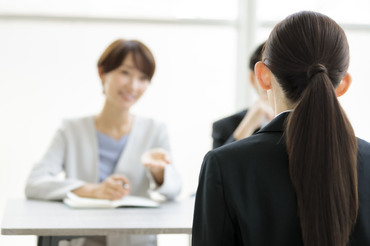 就職面接を受ける就活生の後ろ姿と面接官