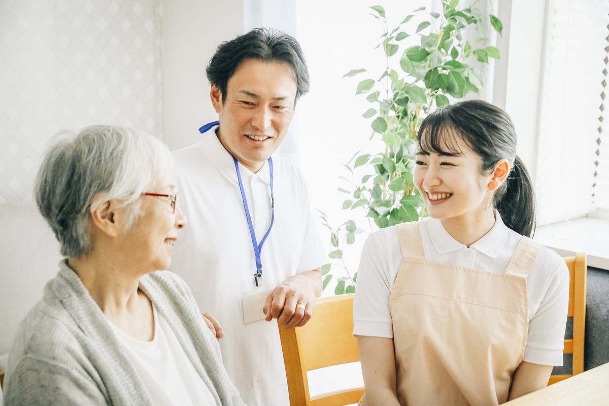 高齢者と話す男女のスタッフ