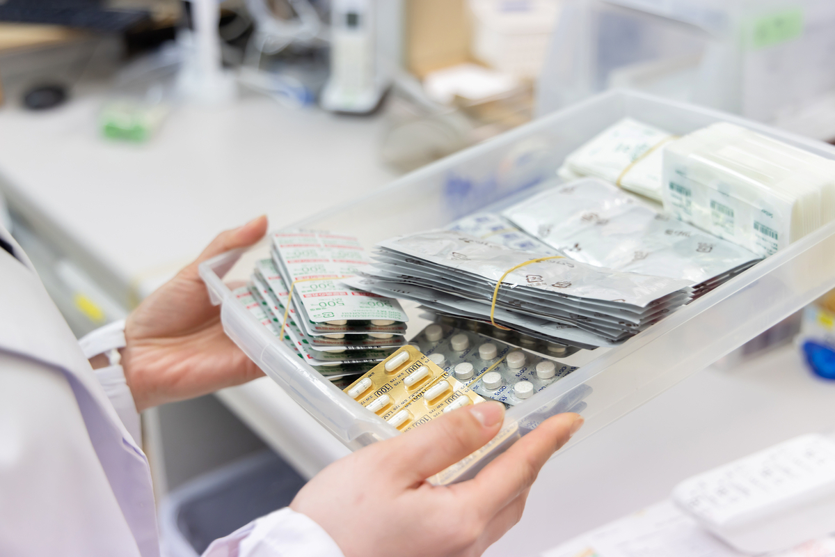 薬の入ったトレイを手にする薬剤師