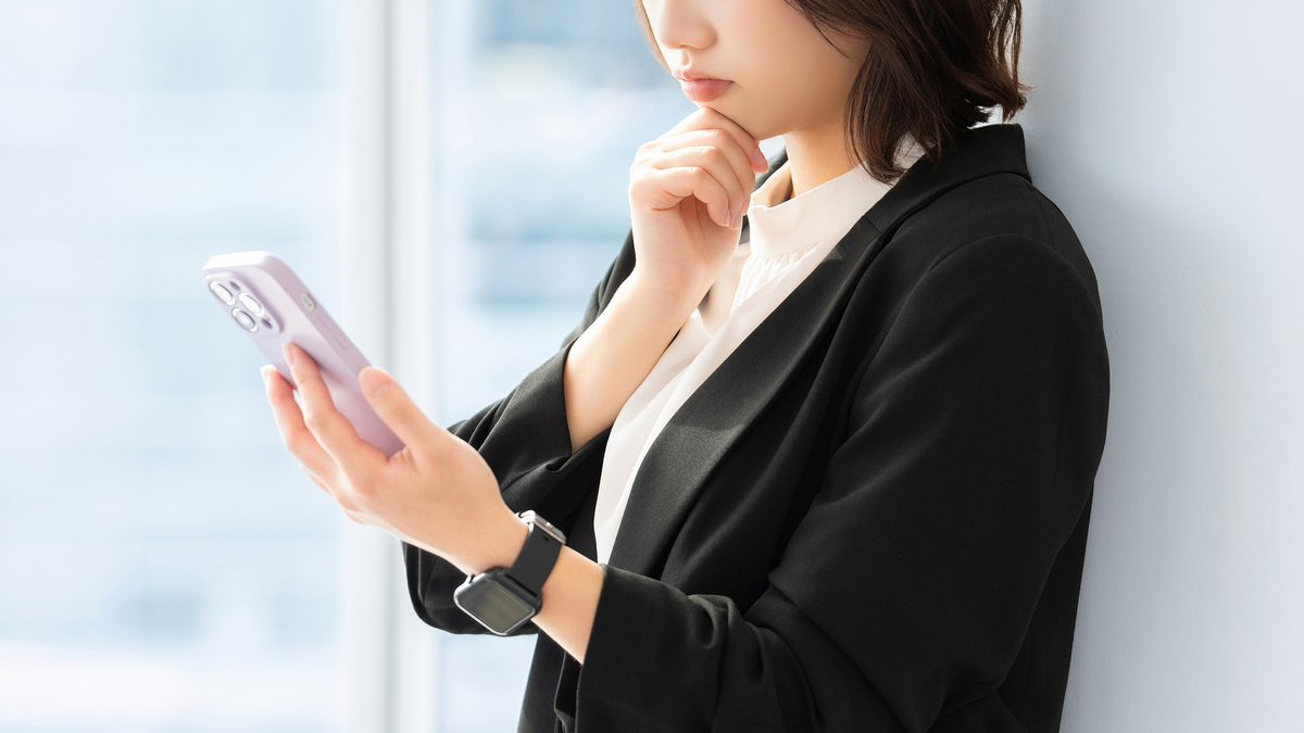 スマホを見て考える女性