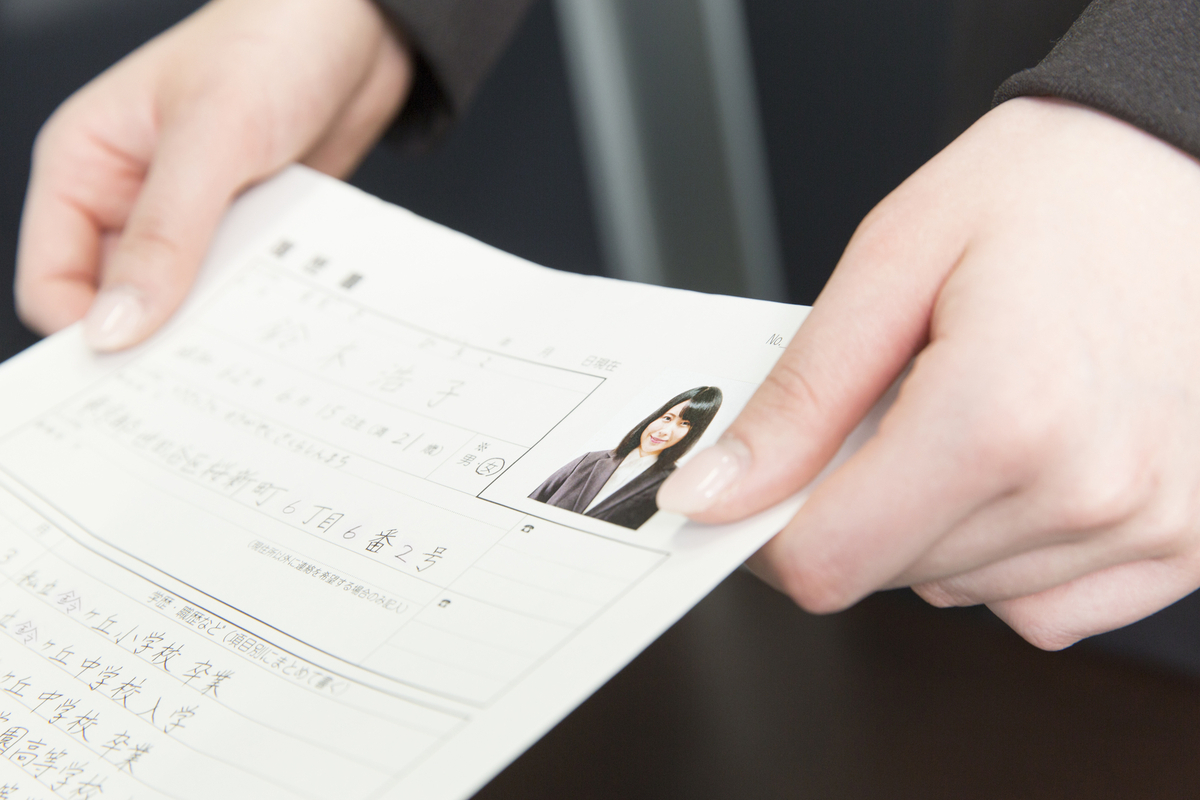 履歴書を手渡しする女性
