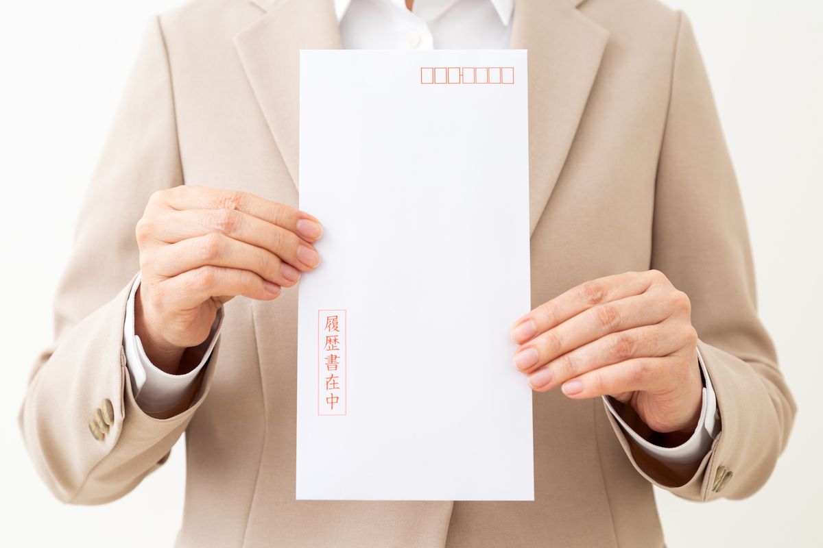 封筒に入った履歴書を持つビジネスパーソン