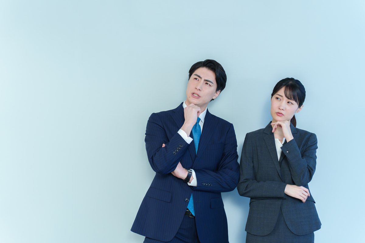 悩むスーツの男女