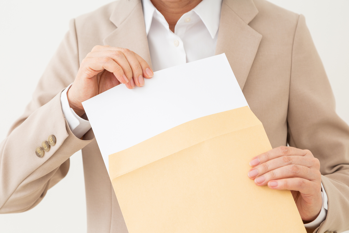 封筒を持つ手元