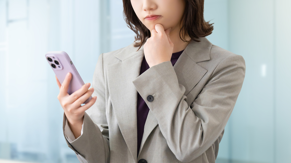 スマホを見て考える女性