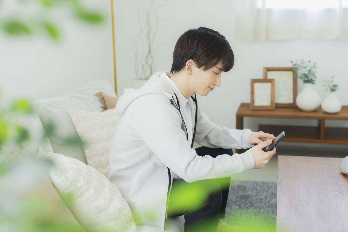 ソファでスマホを操作する男性