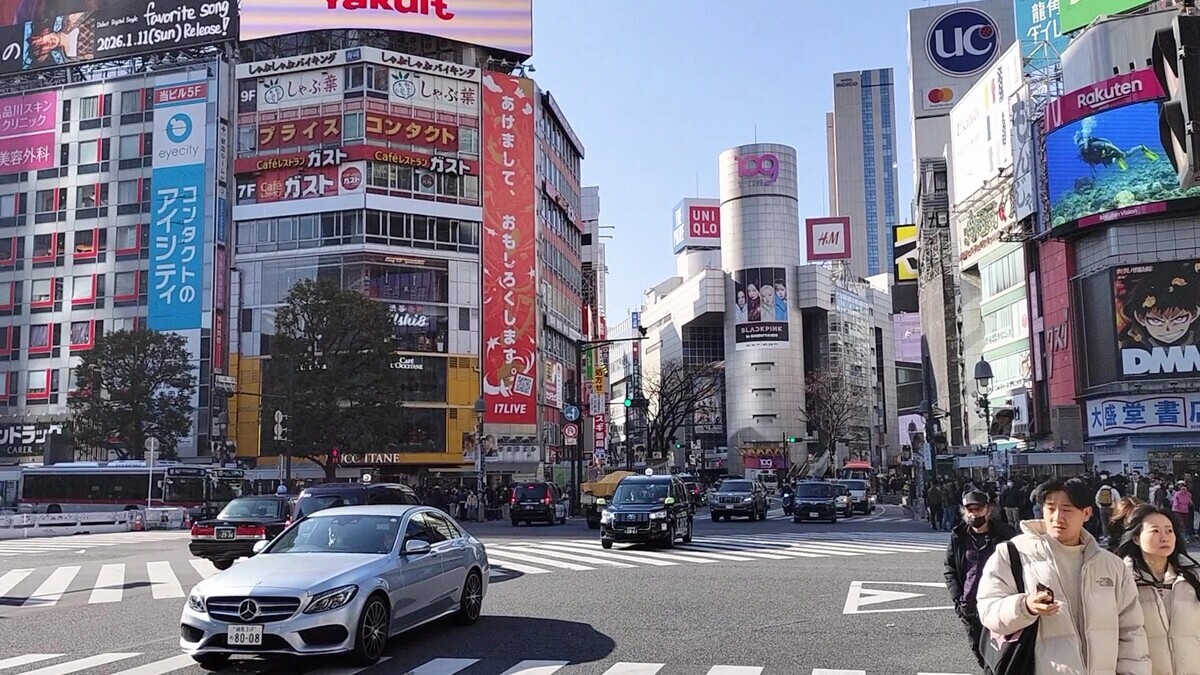 渋谷駅前のスクランブル交差点の写真。雲一つない青空である