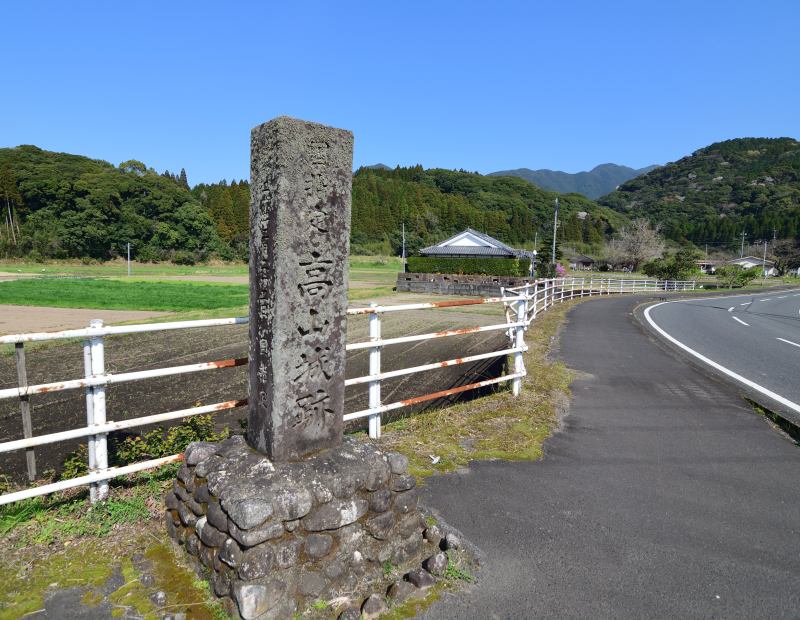 古い石造りの「高山城跡」碑、奥に山城跡も見える