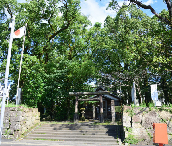 護国神社の鳥居と石垣、境内は木々の緑が覆う