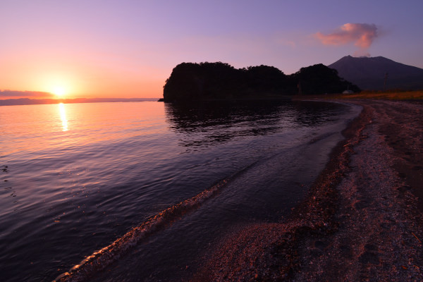 海が夕日に照らされる、島影が浮かび上がる