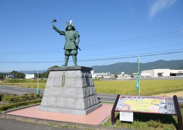 晴天の田園風景の中に立つ銅像