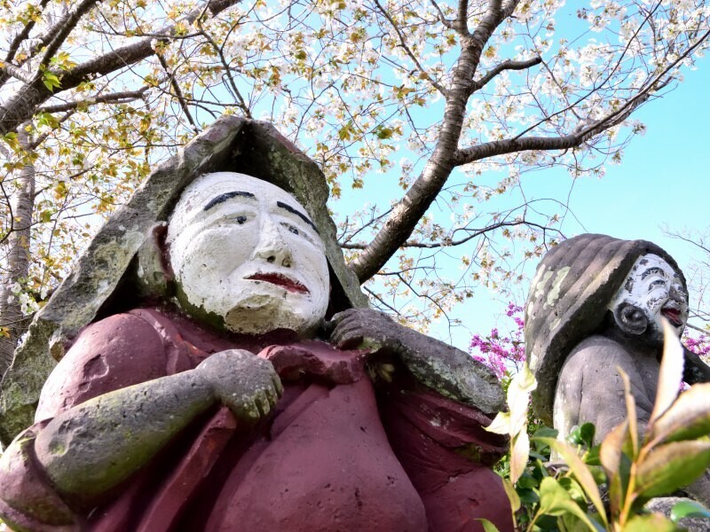 田の神像と桜の花