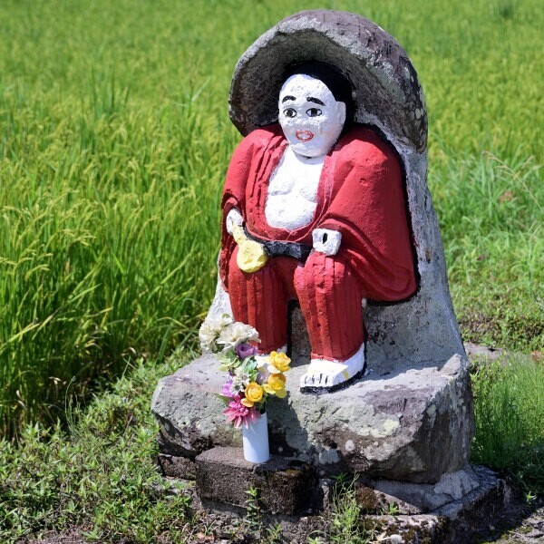 田んぼの横に田の神像