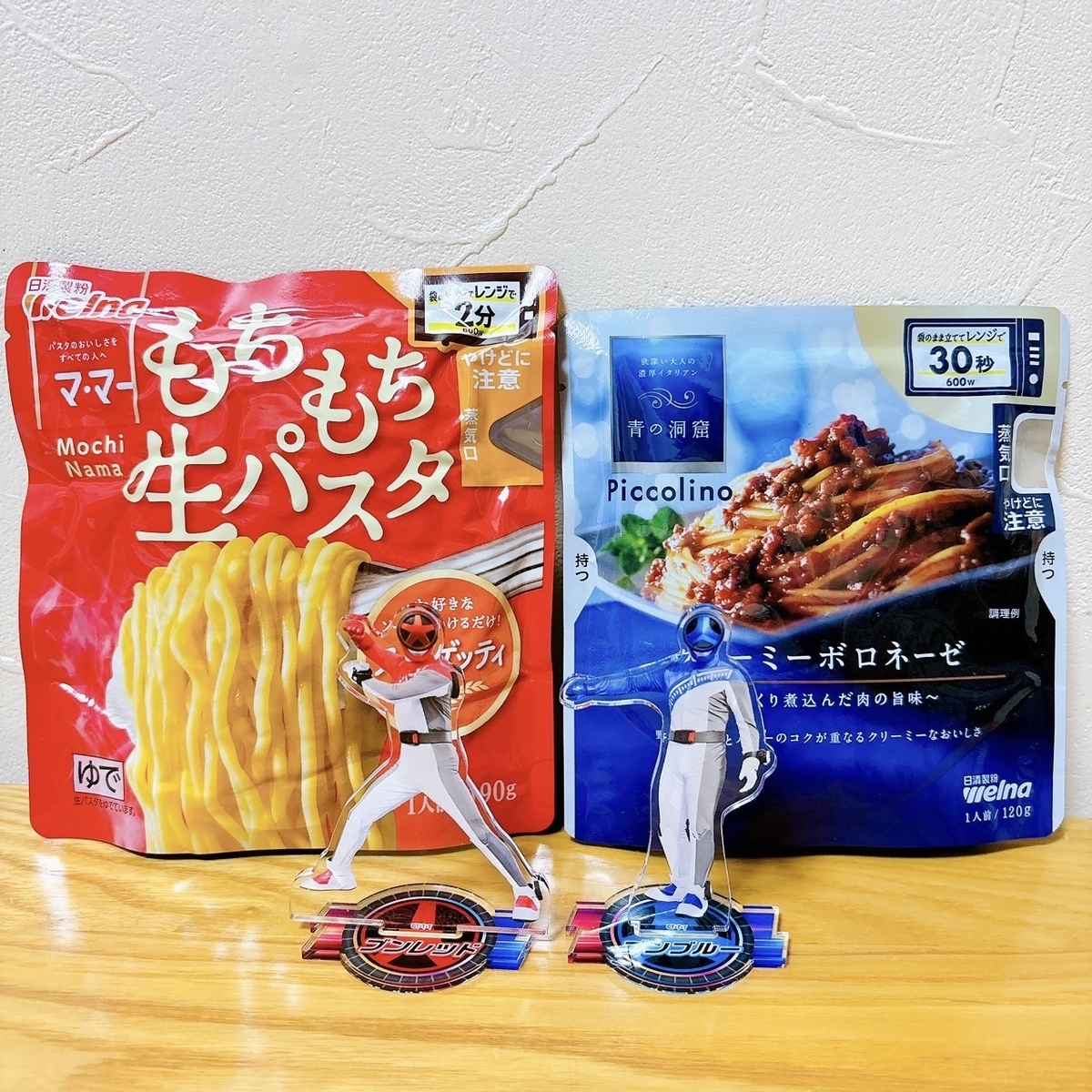 赤いパスタのパッケージ前にブンレッドのアクスタ、青いパスタソースのパッケージ前にブンブルーのアクスタ