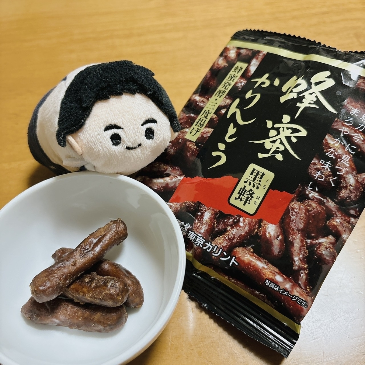かりんとうを食べようとしている阿久瀬錠のぬい