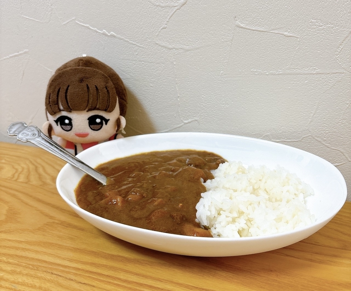 皿にのったいちごカレー（見た目は普通の茶色いルー）とライス、その横にミラのぬいぐるみ。