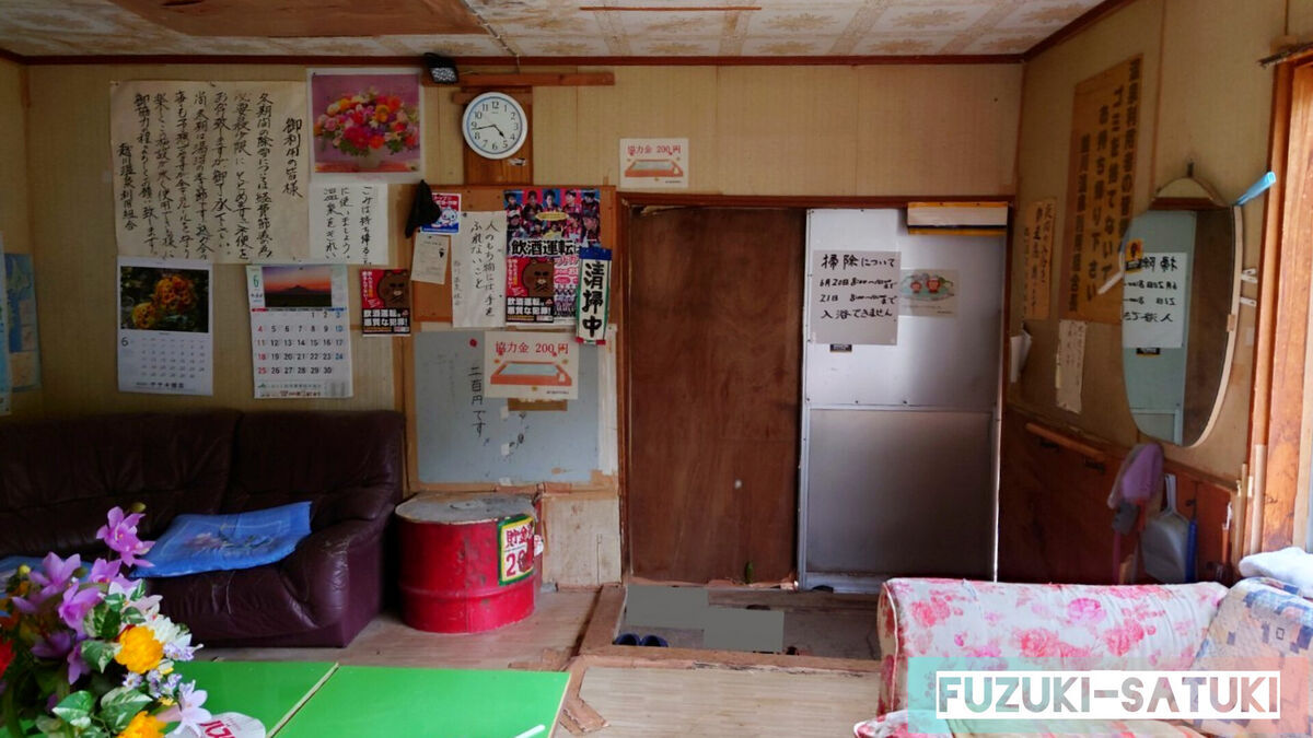 北海道斜里郡斜里町富士150-1に位置する、地元民が守り続ける浴場「越川温泉」の内観。写真は出入り口付近を写したもの。入ってすぐ右手に、赤い「貯金箱」と書かれた協力金２００円を入れる箱がある。