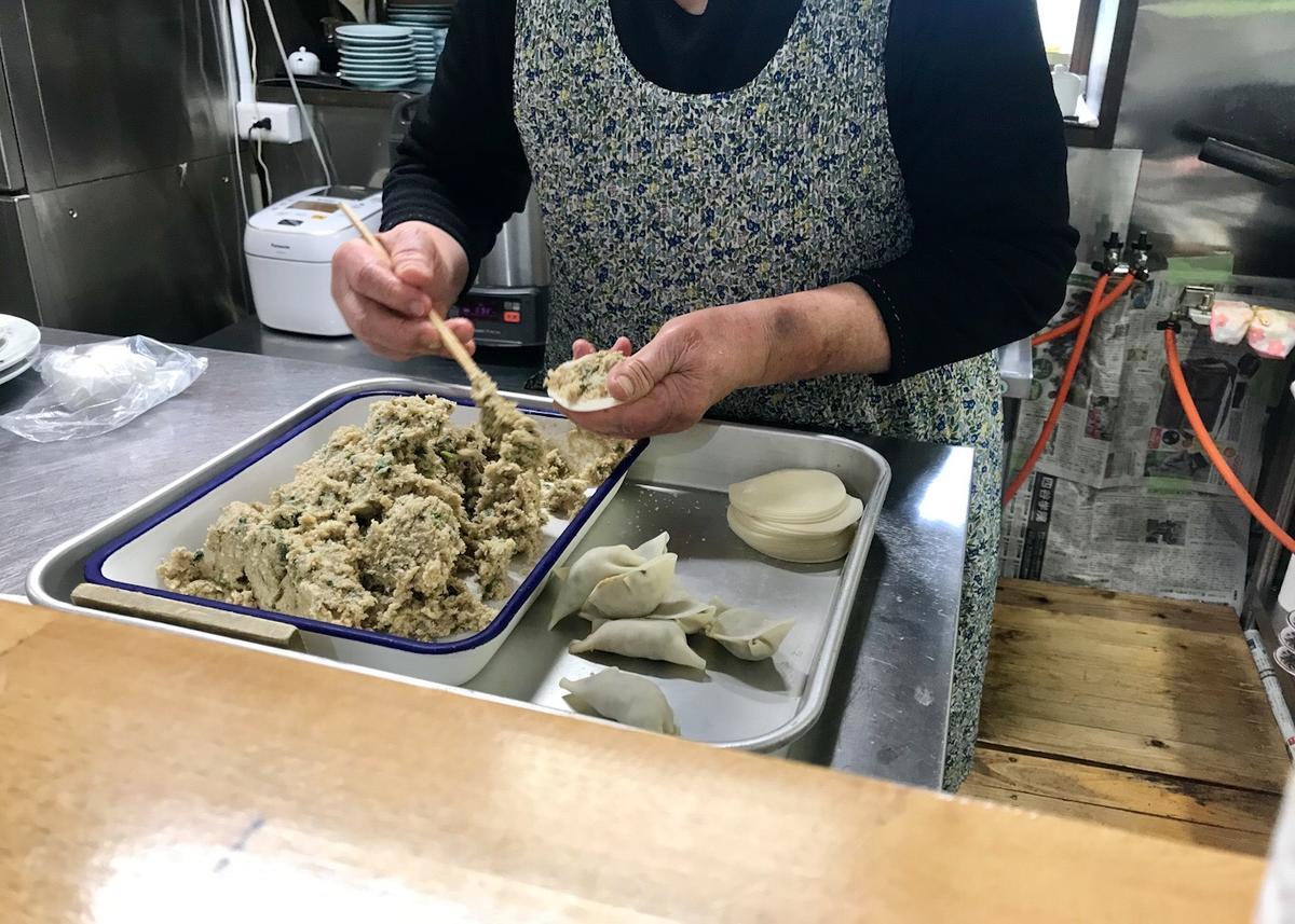 おばちゃんが餃子を包んでいる様子