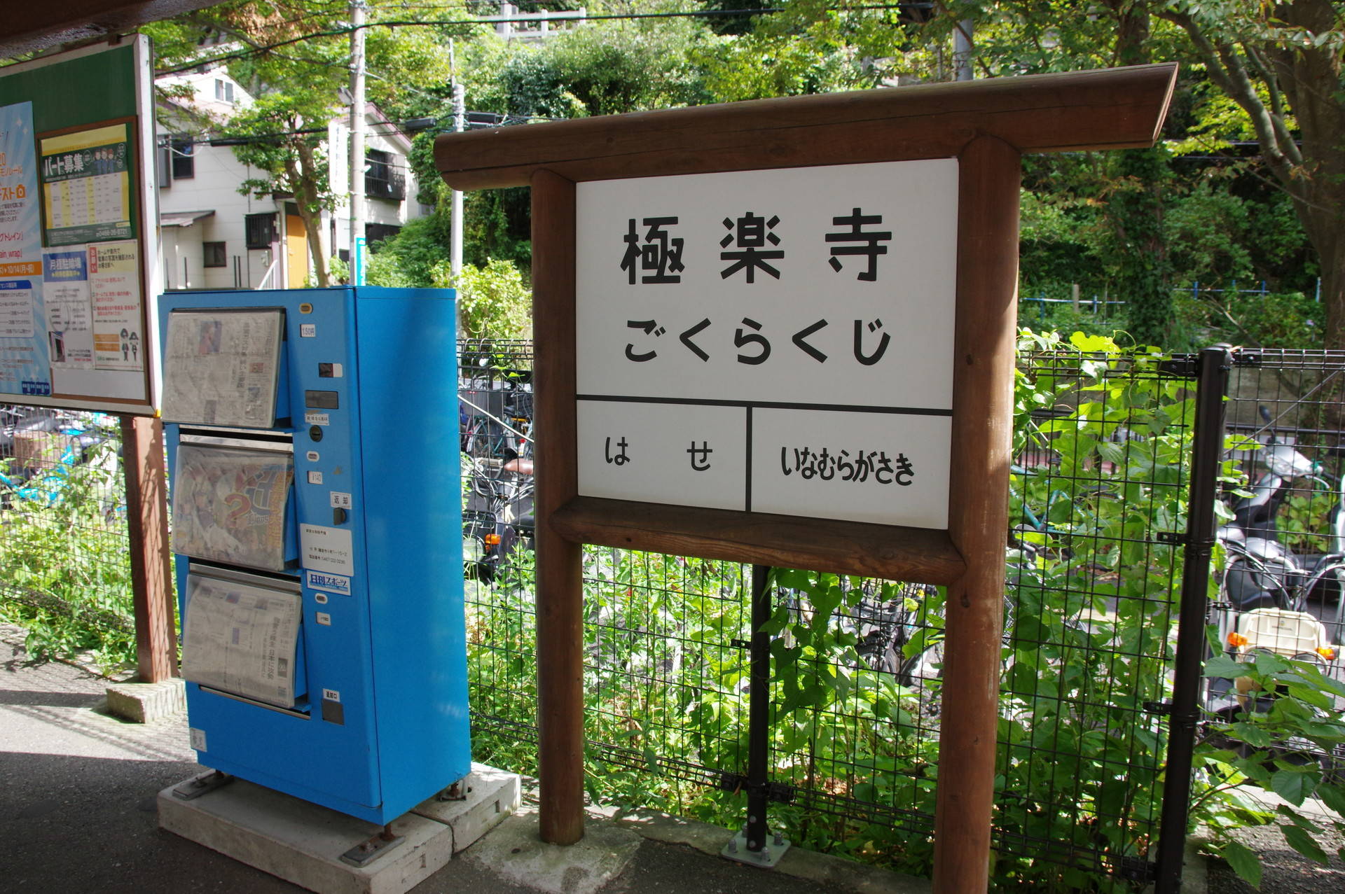 レトロなタイプの駅名標と水色の新聞自販機