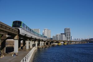 青空の下、運河の横を走る10000形