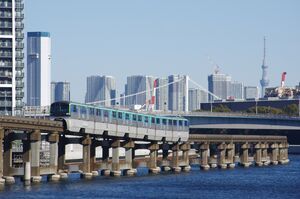 ビル群とスカイツリーを背景に走行する10000形