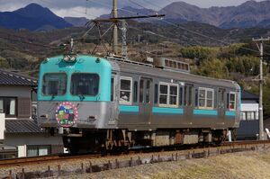 緩やかにカーブした築堤区間を走る7000形(7001・「スマホでe-Tax」HM付き)