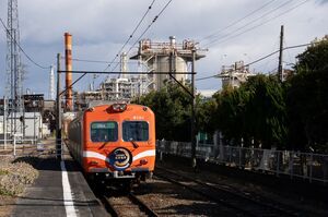 工場を背景に岳南原田駅ホームへ到着する8000形(8001編成)