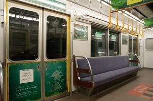 「高安まなびやま」車内。ドア部分に緑色のラッピングがされている