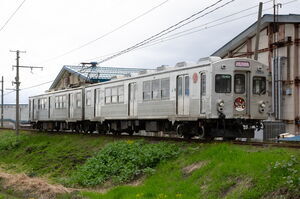 直線区間を走行する7000系(7039編成・無塗装・ピンク幕)