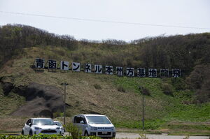 丘の中腹に建てられた「青函トンネル本州方基地龍飛」の看板