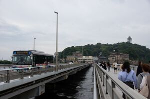 江ノ島をバックに江ノ島大橋を渡る京急バスC2590号車。