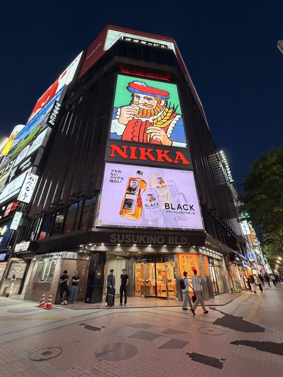 札幌市電と有名看板の1枚 すすきの ラーメン横丁で全コーンを