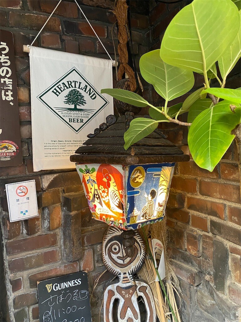 喫茶「さぼうる」の店頭にかけられたランプの写真。赤い鶏と、お月見をする少年の後ろ姿が描かれている